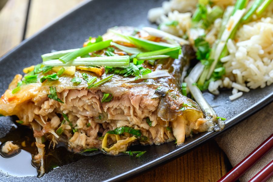 A steamed fish head buried under chopped red chilies