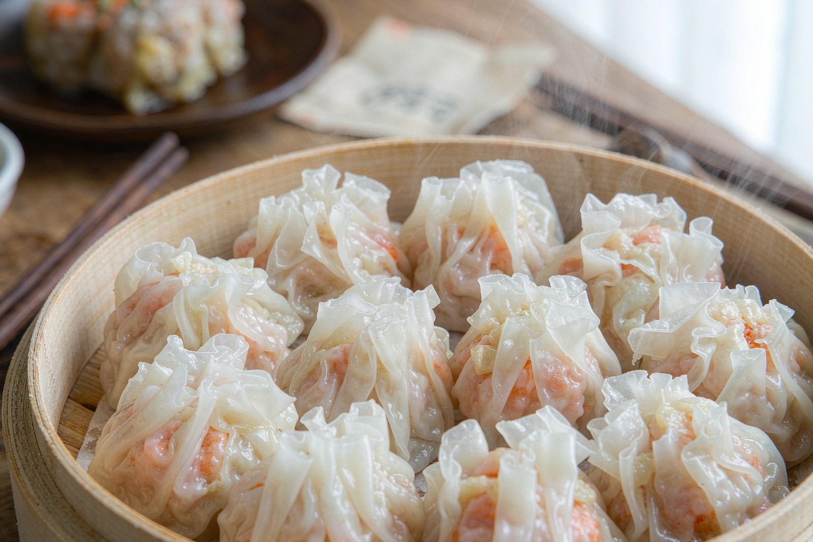 Pleated translucent har gow shrimp dumplings in a steamer