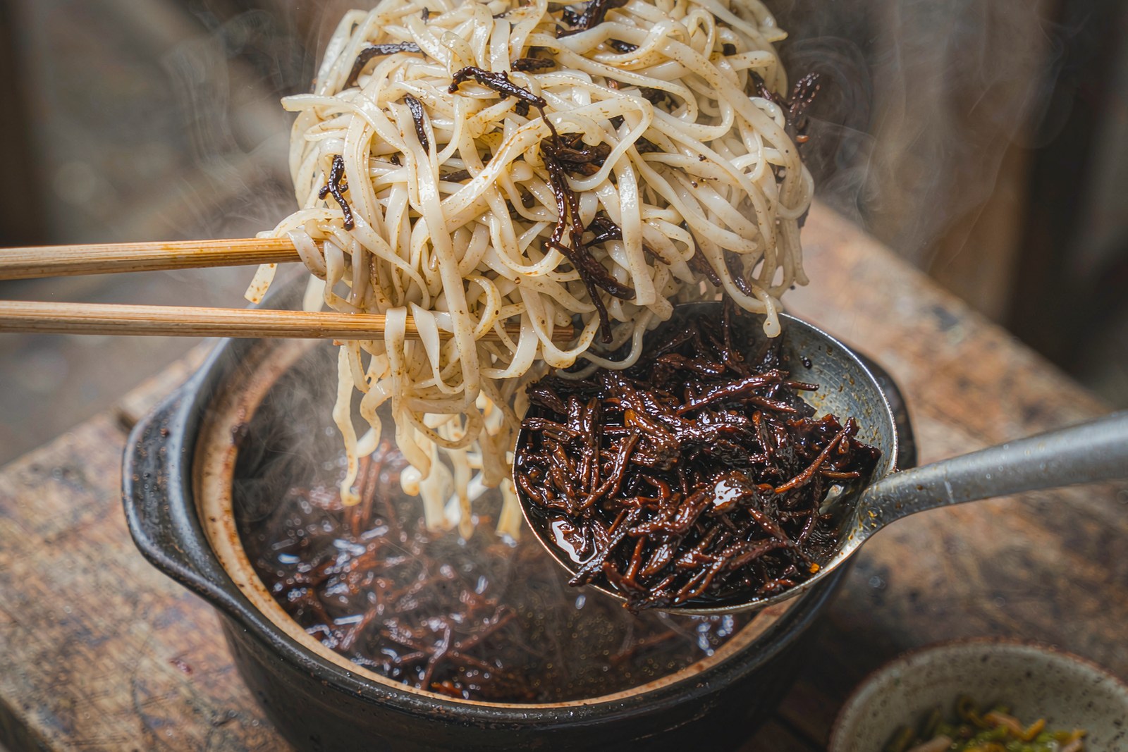 Fresh flat rice noodles dressed with dark braised pork in the pan