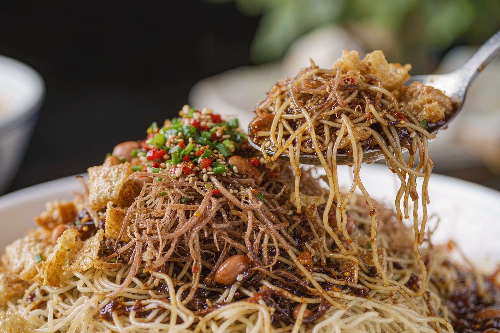 A close view of thin sour noodles glistening with dressing and toppings
