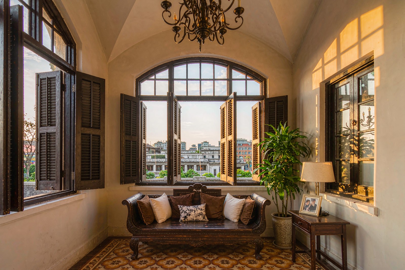 A guesthouse sitting room inside a restored villa with tall windows and tiled floor