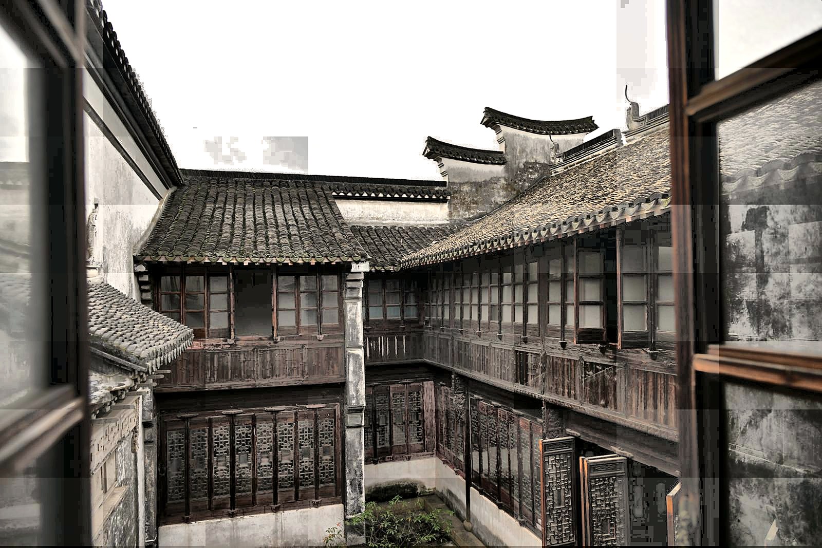 A restored brick courtyard at a Lingnan Tiandi boutique guesthouse, with a tiled fish pond.
