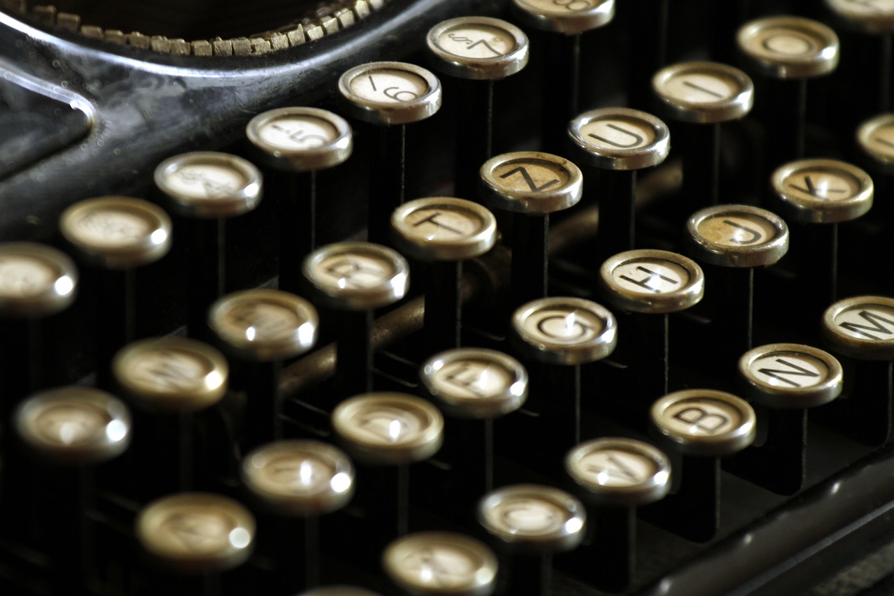 A typewriter and its ribbon resting on an old desk