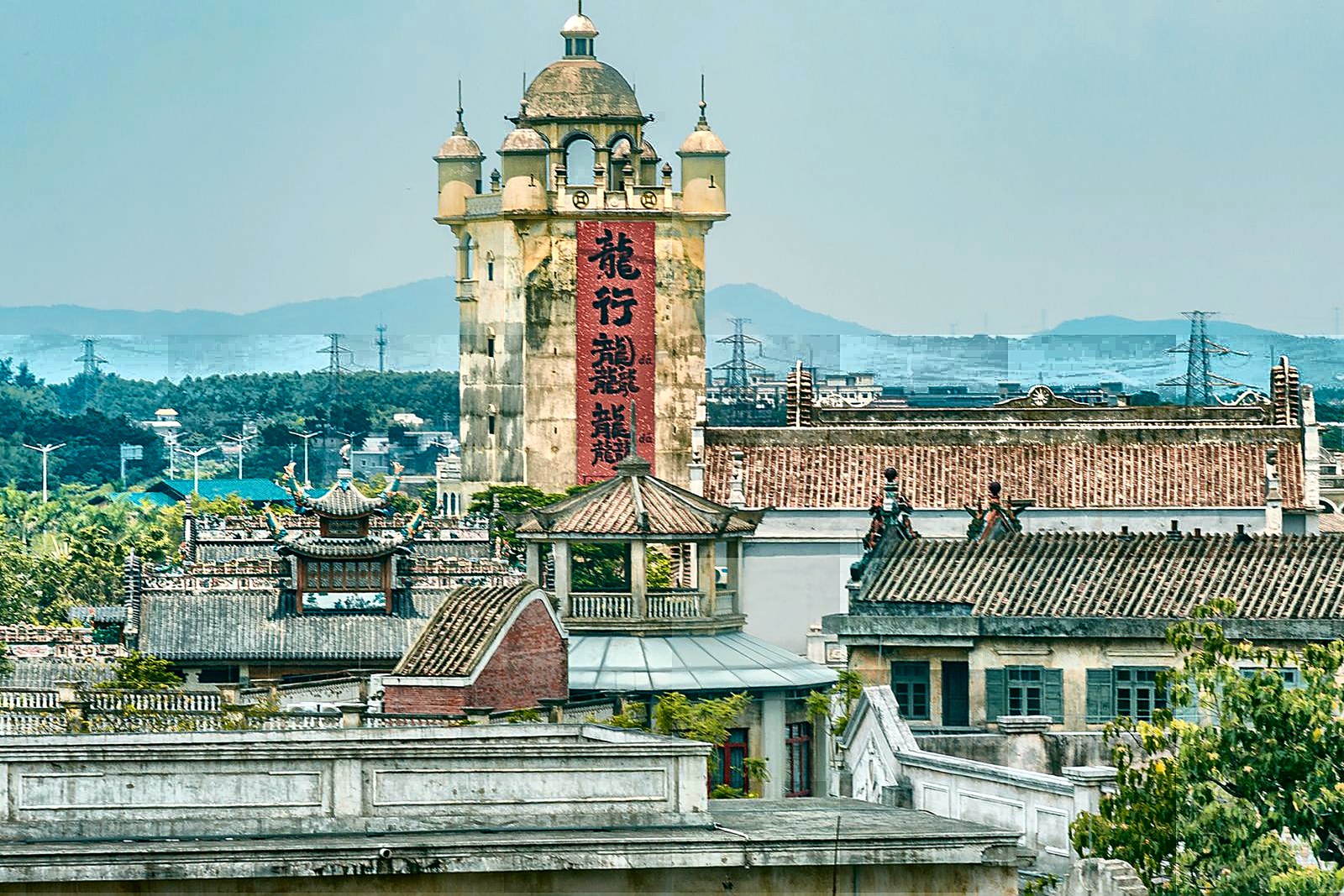 A Kaiping diaolou watchtower rising above the rice fields of a Guangdong village