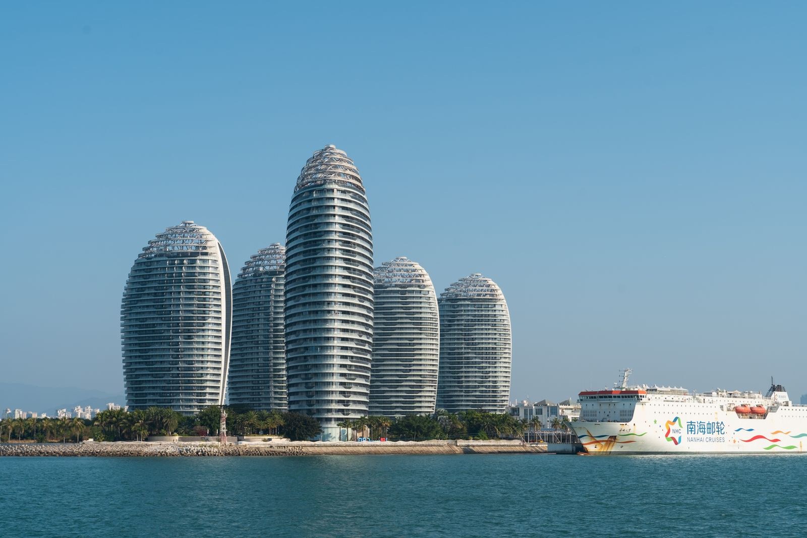 Five curved towers of Phoenix Island rising over the sea at dusk