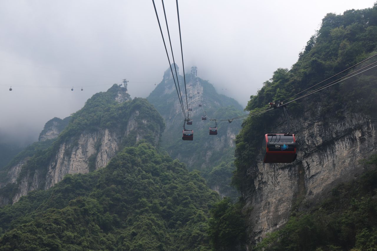 Cable cars ascending Tianmen Mountain through the mist